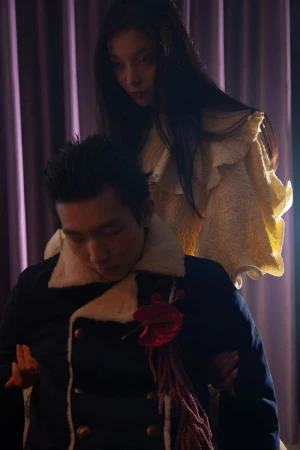 Woman standing behind a seated man in a dark jacket with a shearling collar, photographed by Lean Lui for DNA Magazine Mexico.