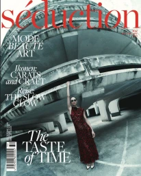 Model wearing a red dress standing in a concrete parking structure for a magazine cover shoot