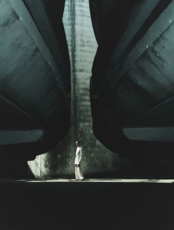 Model standing beneath massive curved concrete bridge structures in Seduction Magazine editorial cover