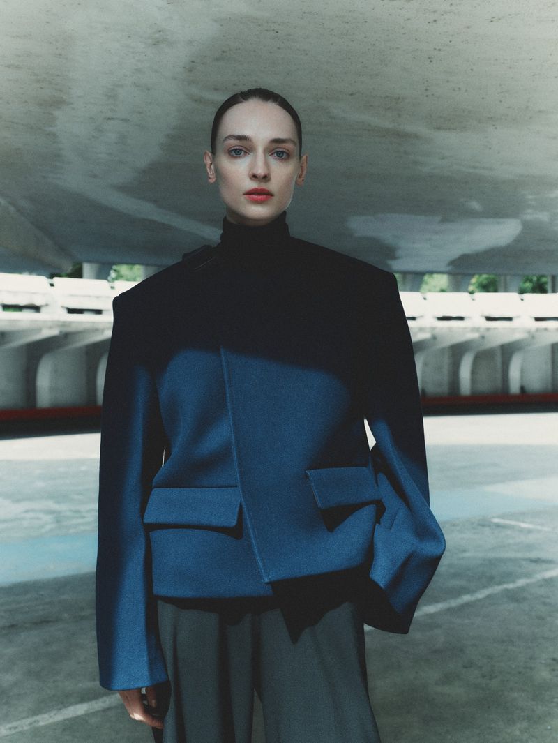 Model Daga Ziober wearing a structured blue jacket and black turtleneck for Seduction Magazine by Gus and Lo.