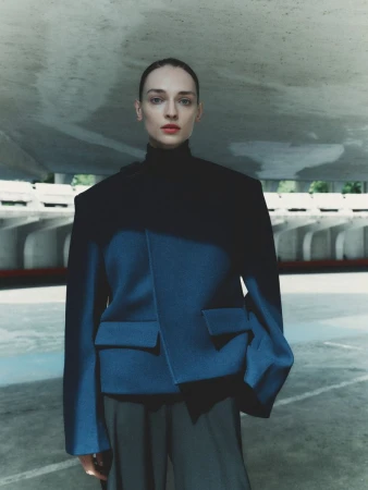 Model Daga Ziober wearing a structured blue jacket and black turtleneck for Seduction Magazine by Gus and Lo.