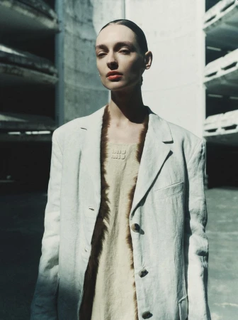 Model Daga Ziober in a white blazer and dress standing outdoors for Sèduction Magazine by Gus&Lo
