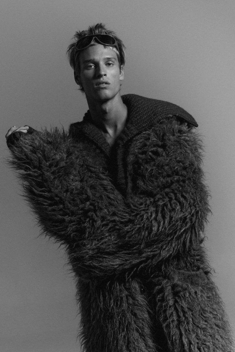 Model wearing a textured shaggy coat and dark sunglasses against a plain neutral background for Numero Netherlands.