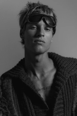 Portrait of male model Yeray Allgayer wearing dark sunglasses and a textured sweater for Numero Netherlands by photographer Inês Santos.