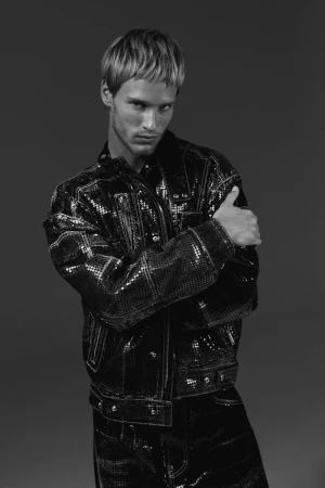 Model Yeray Allgayer in a black sequined jacket against a dark studio background for Numero Netherlands.