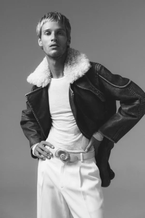 Model Yeray Allgayer in a shearling-collared jacket and white trousers against a neutral background for Numero Netherlands.