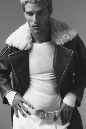 Portrait of model Yeray Allgayer wearing a shearling-collared leather jacket and white belt for Numero Netherlands.