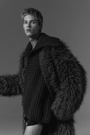 Model Yeray Allgayer wearing a textured shaggy coat and dark ribbed sweater in a monochrome editorial portrait for Numero Netherlands.
