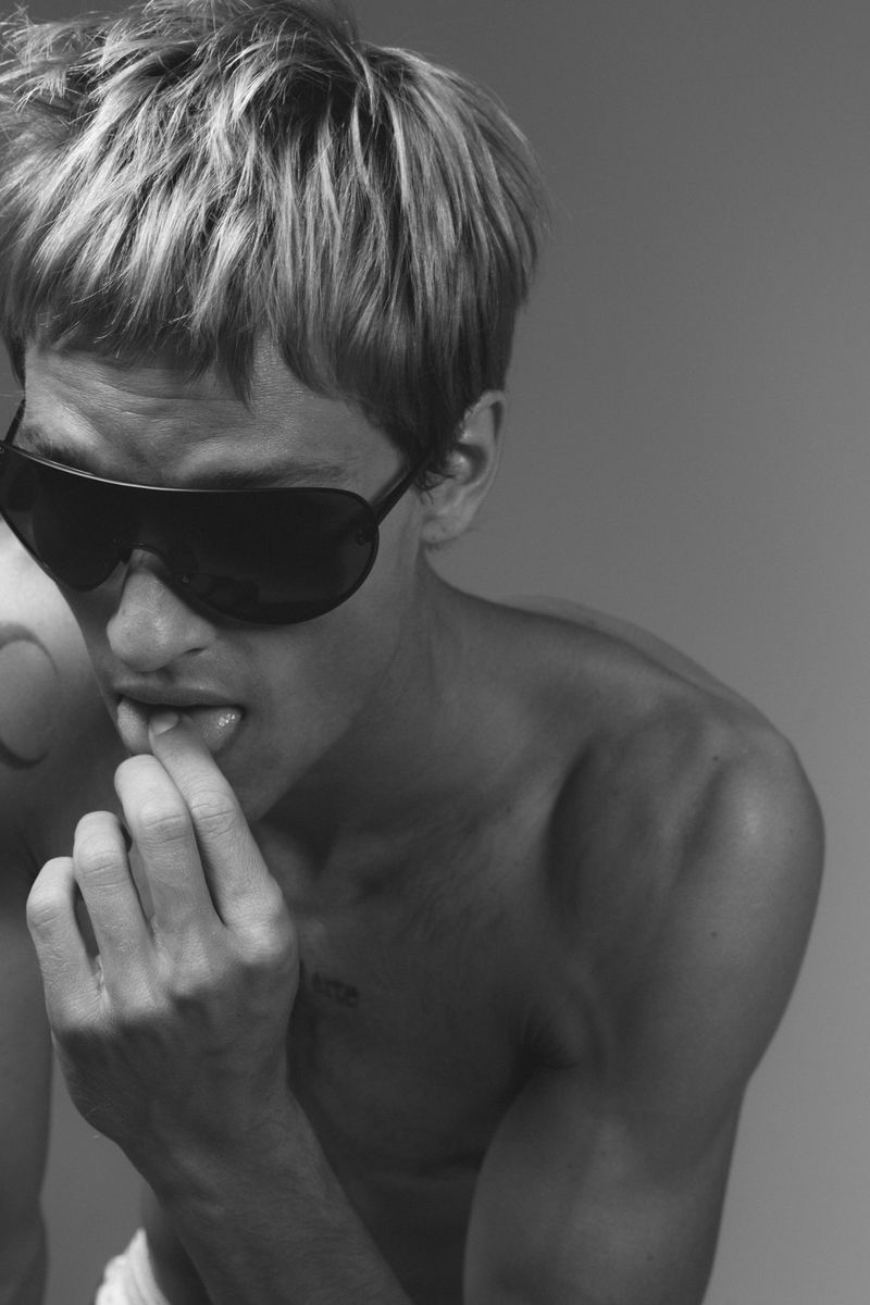 Portrait of model Yeray Allgayer wearing dark sunglasses against a grey backdrop for Numero Netherlands.