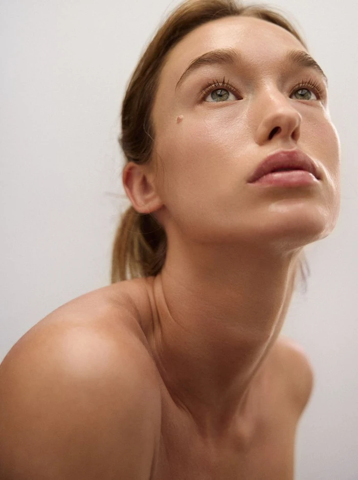 Close-up portrait of a woman looking upward against a plain white background for Russh by Sylve Colless