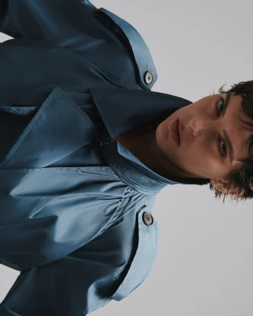 Model wearing a blue coat against a plain white background for L'Officiel Malaysia editorial