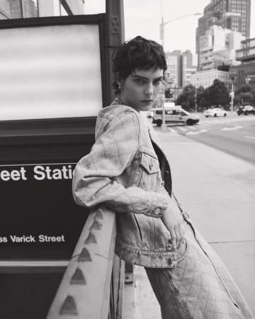 Model in quilted denim jacket leaning against a city subway station entrance in New York
