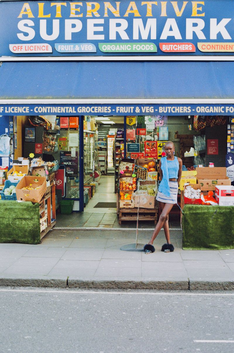 Model posing in front of the Alternative Supermarket storefront for The Great British Storefront editorial.