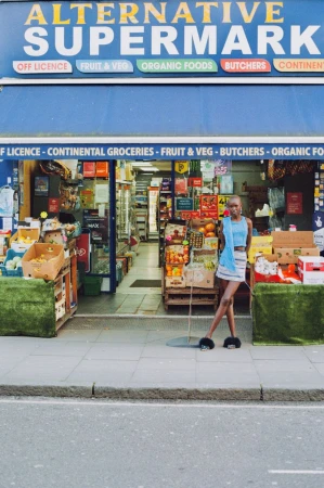 Model posing in front of the Alternative Supermarket storefront for The Great British Storefront editorial.