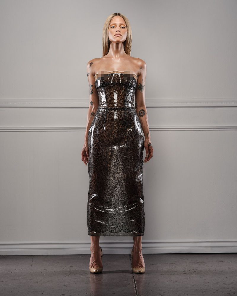 Model Gabbriette standing in a glossy strapless latex dress against a neutral interior wall for CR Fashion Book.
