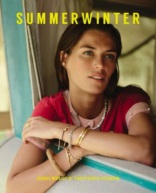 Portrait of a brunette woman with jewelry near a window wearing a pink cardigan, GEORGE MIDGELY BY CHRISTOPHER FERGUSON.