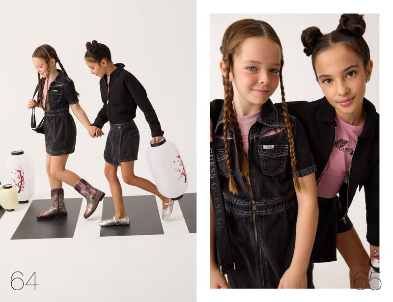 Two young girls in black denim outfits holding lanterns against a plain white background for Guess Kids Pre-Fall 2026.