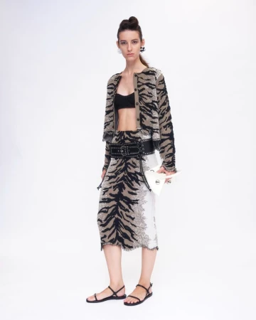 Model wearing a tiger-print cardigan and skirt set with a wide black belt against a plain white background
