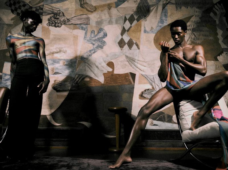 Two male models posing in front of a large abstract mural for Elle Men Brasil, photographed by Lufre.