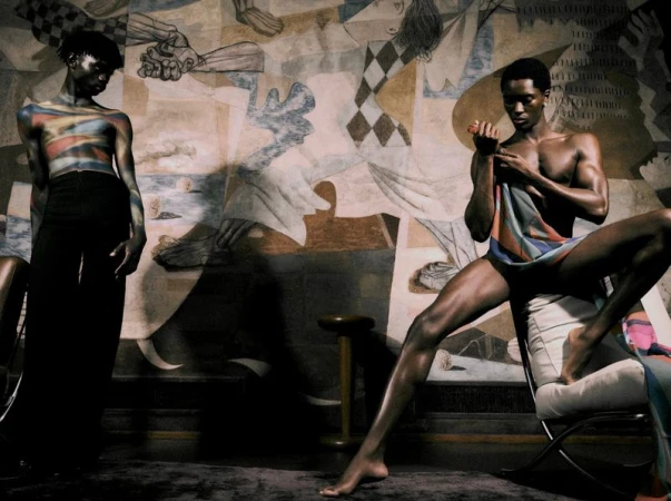Two male models posing in front of a large abstract mural for Elle Men Brasil, photographed by Lufre.