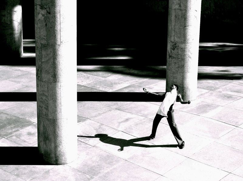 Model Alton Mason posing dynamically amidst monumental stone pillars for Elle Men Brasil, photographed by Lufre.