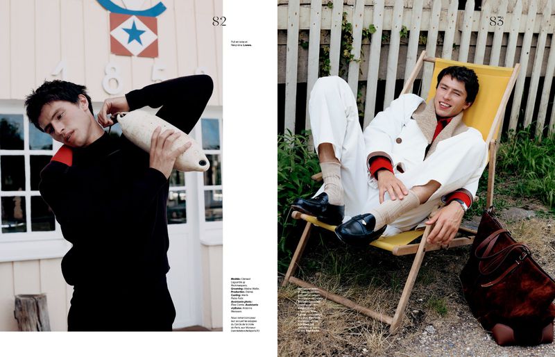 Double-page magazine spread featuring a male model in black holding a buoy and relaxing in a yellow deckchair outdoors