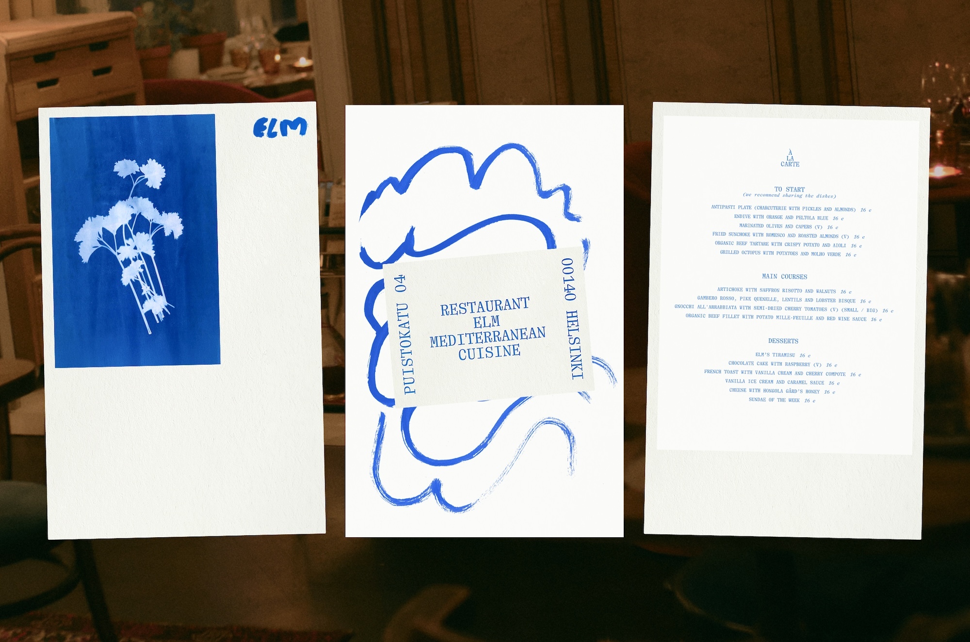 Three white paper sheets showing blue botanical cyanotype art, illustrative branding notes, and a typed restaurant menu.