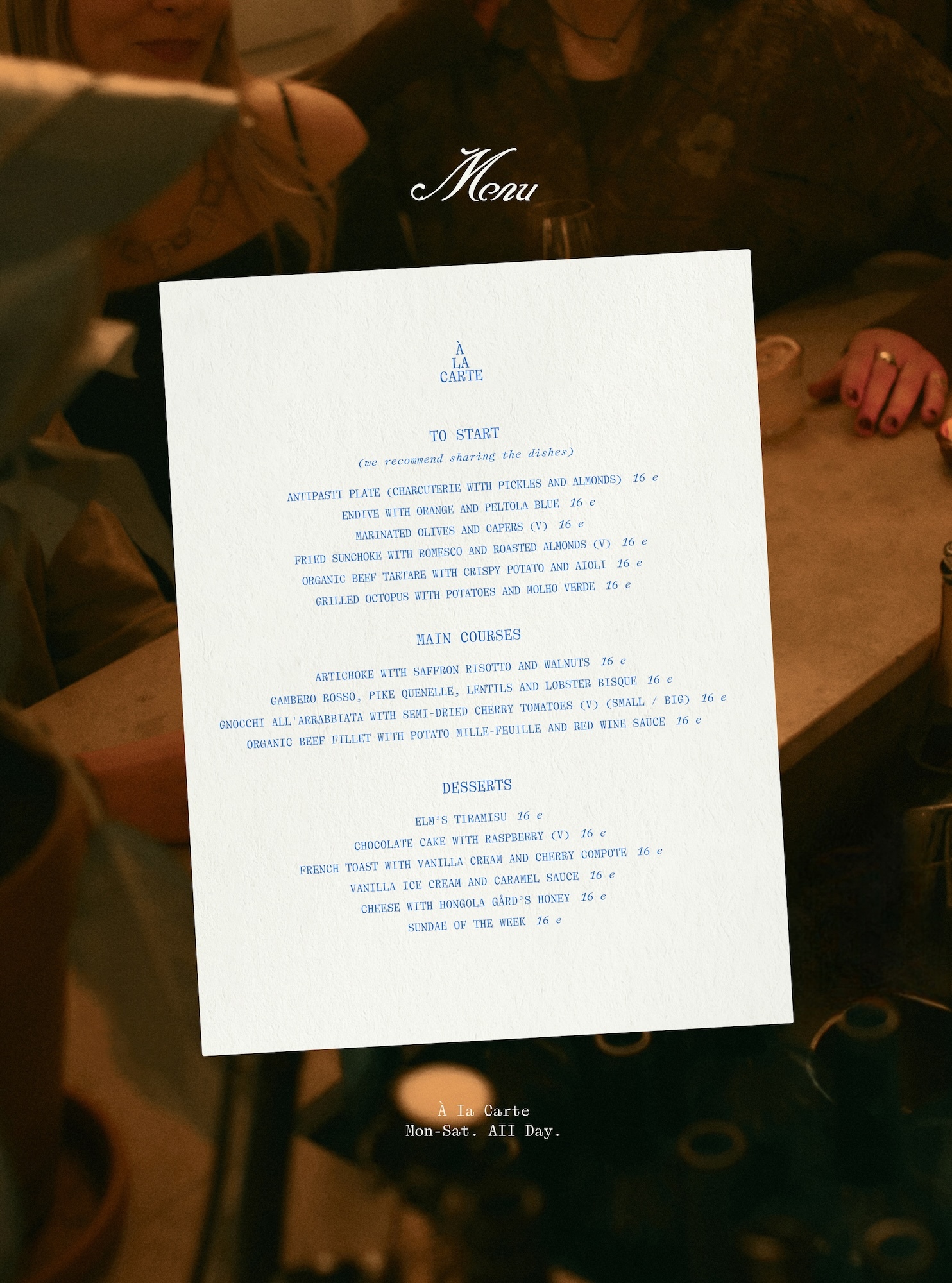 White restaurant menu card displayed centrally over a dim atmospheric table setting with blurred people