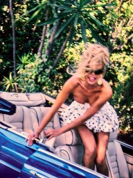 Model Brooks Nader laughing in a convertible car amidst lush tropical foliage for Von Magazine
