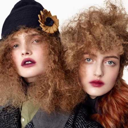 Two female models posing in textured winter coats and hats against a plain white background for Zara Re-form project.