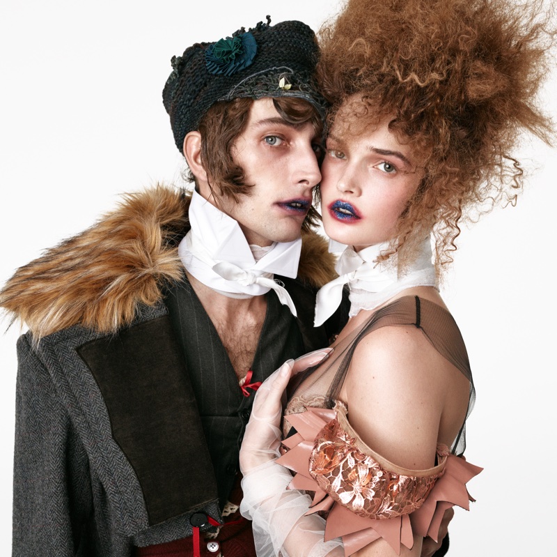 Two models wearing avant-garde historical-inspired attire and dramatic neckwear against a clean white background.