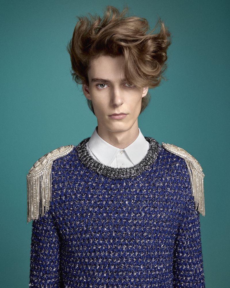 Model Waldemar Durup wearing a blue textured sweater with silver fringe epaulettes against a teal background for Mastermind Magazine.