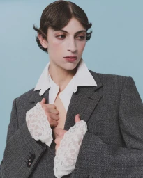 Model in grey blazer and white shirt with lace cuffs for HERO Magazine by photographer Davey Sutton