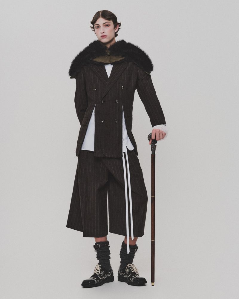 Model Amedeo Mancini wearing tailored pinstripe suit and holding a cane for HERO Magazine, photographed by Davey Sutton.