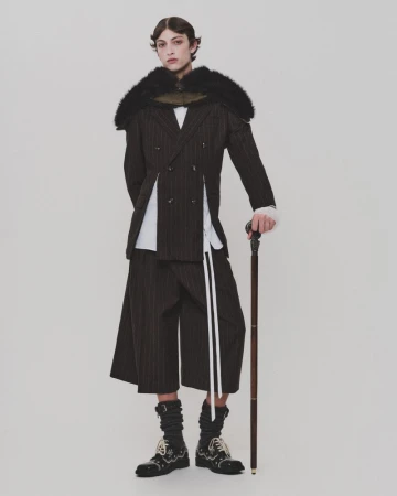 Model Amedeo Mancini wearing tailored pinstripe suit and holding a cane for HERO Magazine, photographed by Davey Sutton.