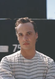 Portrait of actor Frank Dillane wearing a striped shirt against a dark background for Crash Magazine.