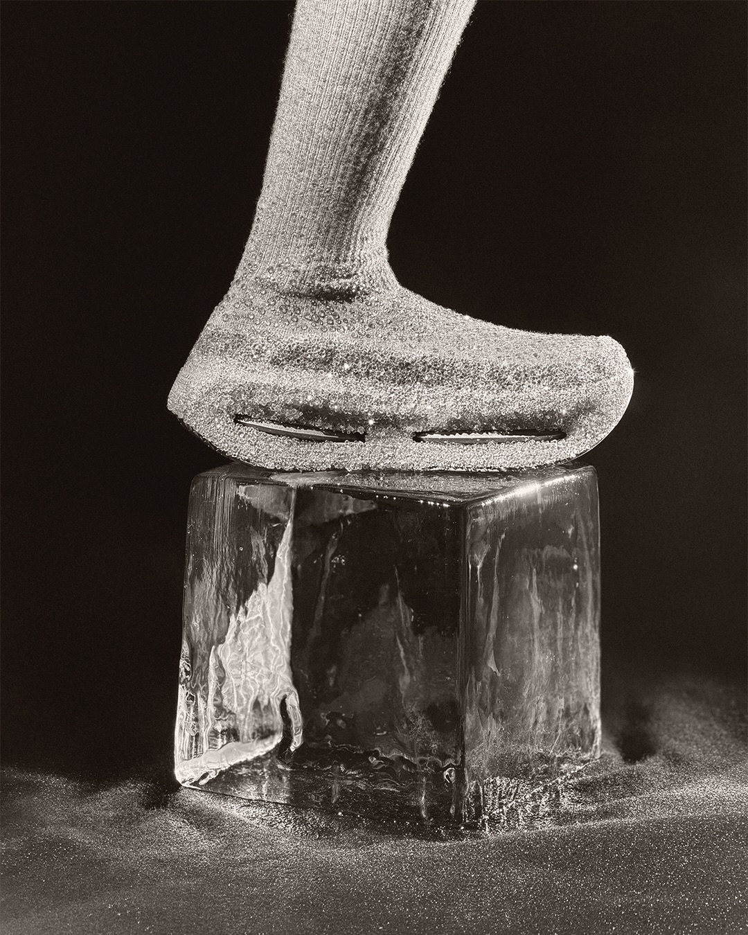 Close-up of a sneaker on a clear ice block against a dark background for the Nike Atelier project.