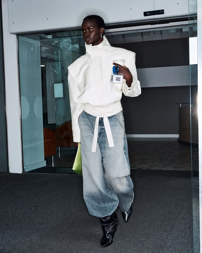 Model in structured white jacket and wide-leg denim walking past glass doors for ASOS Autumn 26