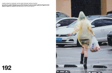 Model Xiao Wen Ju in a translucent yellow raincoat walking through a wet parking lot holding a plastic bag