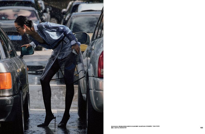 Model Xiao Wen Ju leaning between cars on a wet city street in an editorial for Numero China