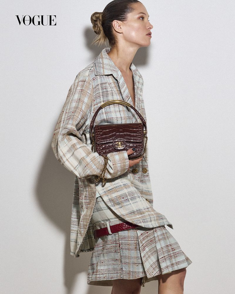 Model Hana Jirickova in plaid jacket holding dark red handbag for Vogue Thailand