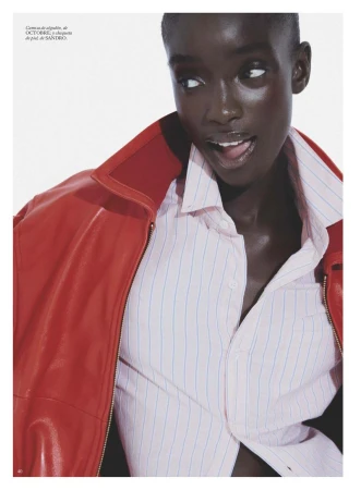 Close-up portrait of model Maty Fall wearing a bright red leather jacket over a striped button-down shirt for Vogue España.