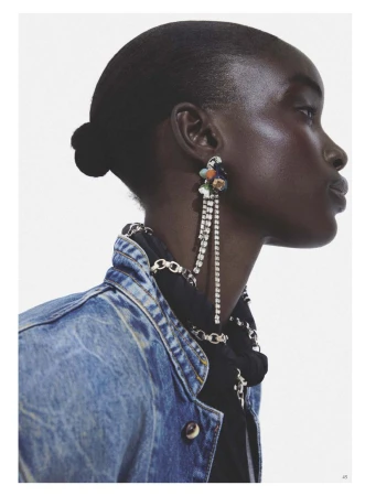 Profile portrait of model Maty Fall wearing a denim jacket and sparkling drop earrings for Vogue Espana