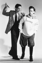 Two male models posing for HERO Magazine editorial with one holding a knife behind the other in a studio setting