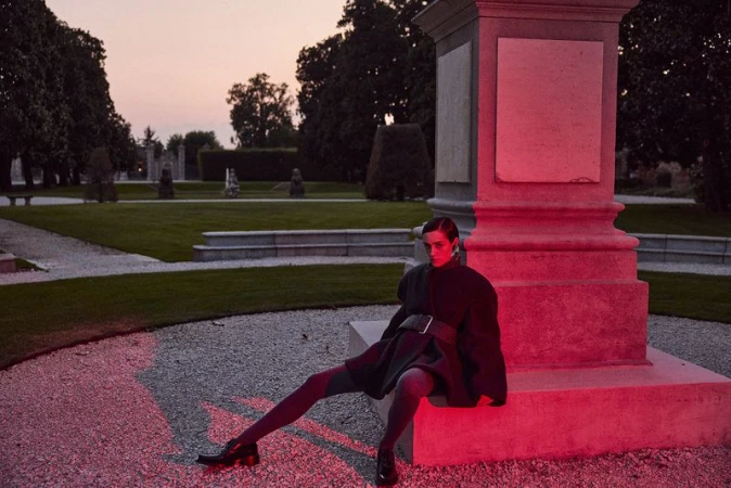 Model Kim Schell posed against a stone monument in a park at sunset for an AMICA Magazine editorial