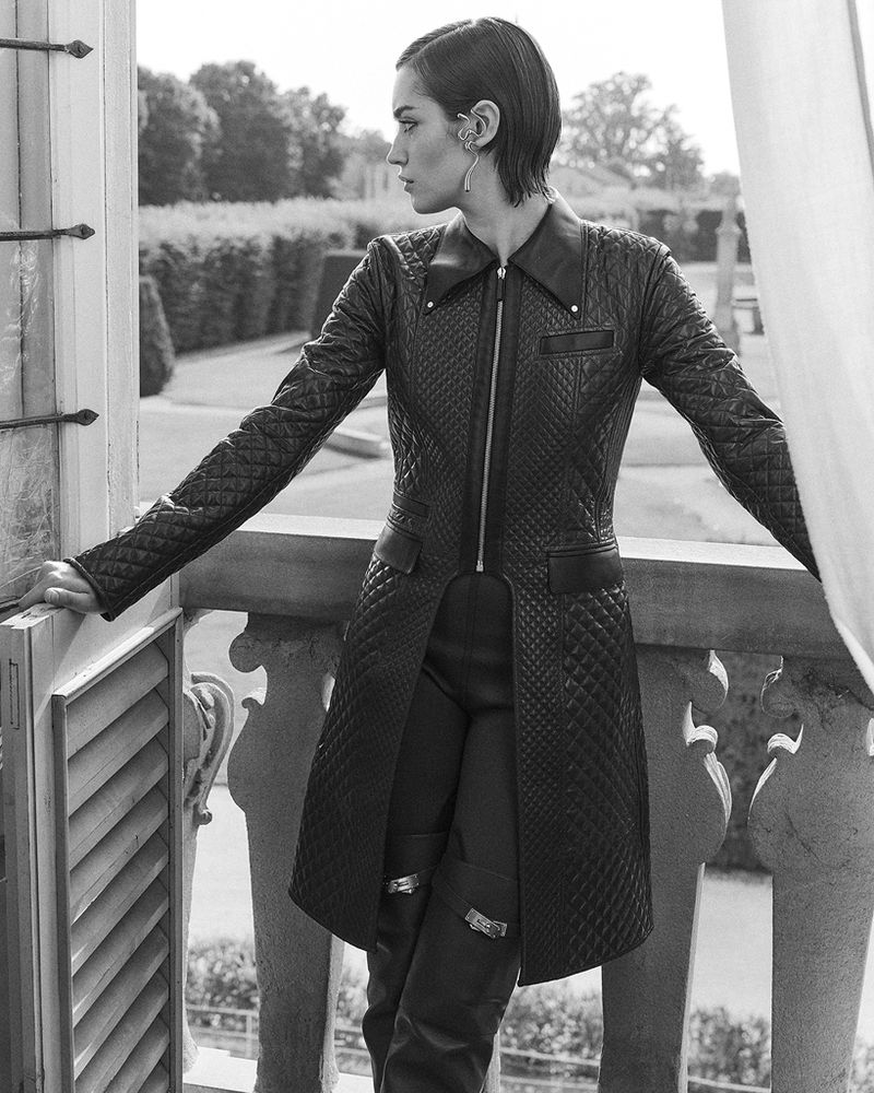 Model Kim Schell wearing a quilted leather coat by a balcony for AMICA Magazine photographed by David Roemer