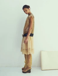 Model Valery Sergeeva wearing a translucent beige dress and tall platform boots for Dazed Magazine