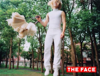 Man wearing a white sleeveless top and white pants floating outdoors among trees holding a ruffled skirt for The Face China