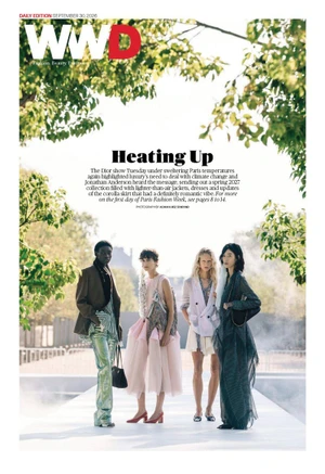Four fashion models standing together outdoors on a white runway beneath overhead tree foliage for WWD magazine cover