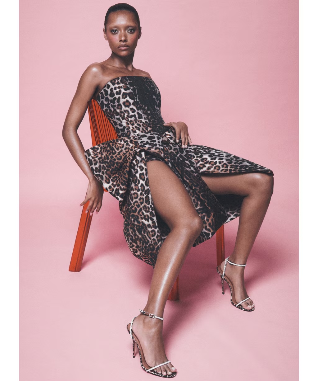 Sophie Wilde seated on an orange chair wearing a leopard print strapless dress for Vogue Australia October 2026